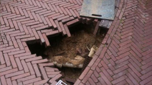 Inspectie van verzakking toont de oorzaak. Lekkage aan de riool